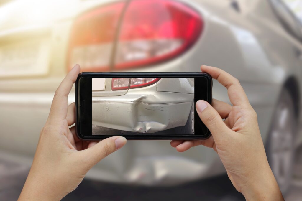 Hand holding smart phone take a photo at The scene of a car crash